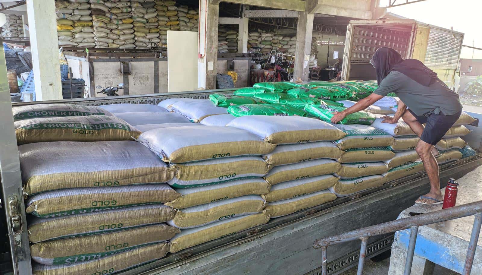 Feed bags being loaded onto a delivery truck